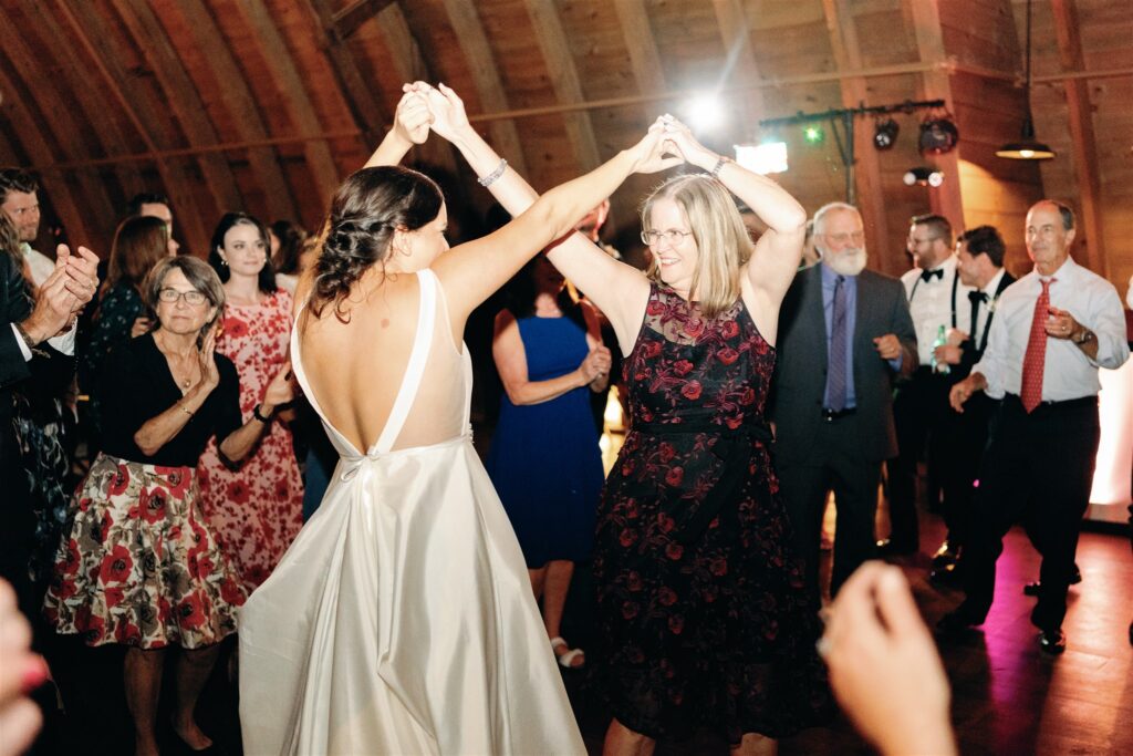 Bride dancing with wedding guest at Sweeney Barn in Manassas, VA